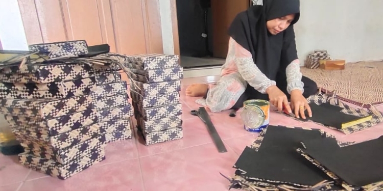 Mainiar, pemilik IKM Tika Raja, saat sedang mengerjakan produk pesanan dari para pembeli di luar Aceh. IKM Tika Raja merupakan binaan Dinas Perindustrian dan Perdagangan (Disperindag) Aceh, beralamat di Gampong Sagoe, Pidie Jaya
