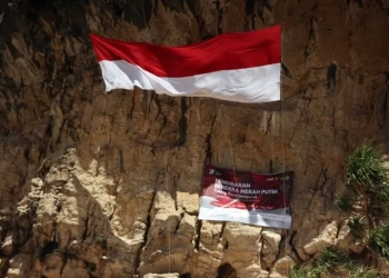 Bendera merah putih berukuran 15x4 meter berkibar di tebing Lampuuk. (17/8/2022). (Foto: Antara/Nurul Hasanah)