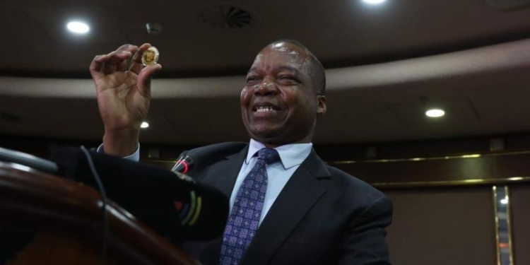 Gubernur Bank Sentral Zimbabwe (RBZ) John Mangudya menampilkan koin emas yang baru diperkenalkan selama konferensi pers di Harare, Zimbabwe, 25 Juli 2022. ANTARA/ Xinhua/Shaun Jusa
