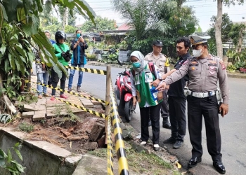 Kepolisian membatasi lokasi kejadian pengendara motor diduga mahasiswi IPB terperosok ke selokan di belokan Jalan Dadali Kota Bogor yang terjadi pada Selasa (11/10/2022) sore. (ANTARA/Linna Susanti)
