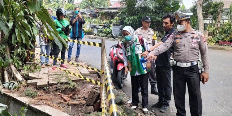 Kepolisian membatasi lokasi kejadian pengendara motor diduga mahasiswi IPB terperosok ke selokan di belokan Jalan Dadali Kota Bogor yang terjadi pada Selasa (11/10/2022) sore. (ANTARA/Linna Susanti)