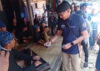 Sandiaga Uno memberikan uang Rp ribu kepada pemain pemusik tradisional masyarakat Badui di pedalaman Kabupaten Lebak, Sabtu (15/10). ANTARA/Mansur