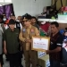 Kepala BNPB RI Letjen TNI Suharyanto menyerahkan secara simbolis bantuan korban banjir senilai Rp750 juta kepada warga pengungsi di Aceh Tamiang, Selasa (8/11/2022). (ANTARA/Dede Harison)