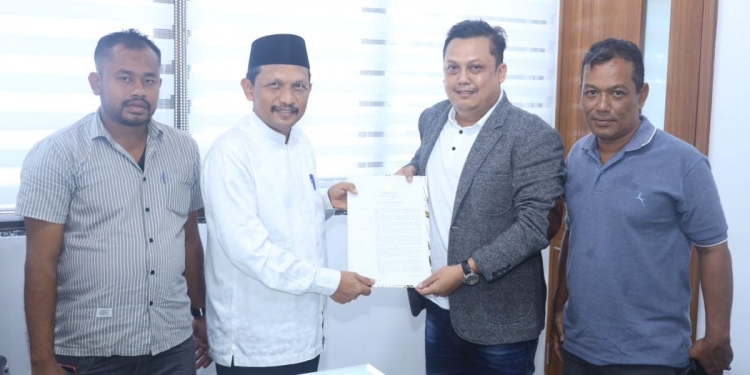 Asisten Pemerintahan dan Keistimewaan Aceh, M. Jafar, menyerahkan Surat Keputusan (SK) Pengangkatan Ketua Badan Reintegrasi Aceh (BRA) yang baru kepada Suhendri, di Kantor Gubernur Aceh, Banda Aceh, Jumat (25/11/2022). (Dok. Humas Aceh)
