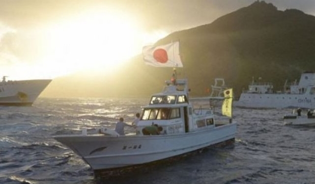 Kapal pengawas laut China Haijian No.51 (tengah) berlayar di dekat kapal-kapal Penjaga Pantai Jepang (kanan dan kiri) dan sebuah kapal nelayan Jepang (depan, kedua kiri), di perairan dekat Pulau Uotsuri, salah satu pulau dari kepulauan Senkaku/Diaoyu di Laut China Selatan, Senin (1/7). Jepang menghadapi ancaman serius yang semakin meningkat dari China dan Korea Utara, dalam laporan Kementerian Pertahanan Selasa kemarin, sementara politisi yang berkuasa menyerukan kepada militer untuk meningkatkan kemampuan mereka dalam menghadapi ancaman tersebut. (REUTERS/KYODO)