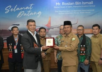 Asisten Administrasi Umum Sekda Aceh, Iskandar, didampingi Pj. Bupati Aceh besar, Muhammad Iswanto, dan Kadisbudpar Aceh, Almuniza Kamal, menyerahkan cinderamata saat menyambut kedatangan Global Head of Sales dari Malaysia Airlines Group, Roslan bin Ismail beserta rombongan pada penerbangan perdana pesawat Firefly di Bandara Internasional Sultan Iskandar Muda, Blang Bintang, Aceh Besar, Senin, (7/11/2022). (Dok. Humas Aceh).