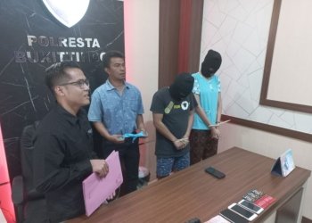 Kasatreskrim Polresta Bukittinggi AKP Fetrizal bersama dua pelaku kasus TPPO yang ditangkap di sebuah hotel. (ANTARA/Alfatah)
