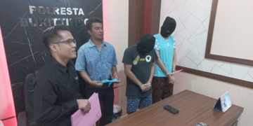 Kasatreskrim Polresta Bukittinggi AKP Fetrizal bersama dua pelaku kasus TPPO yang ditangkap di sebuah hotel. (ANTARA/Alfatah)