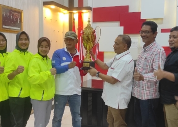 Pelatih muaythai, Syarwan Saleh bersama para atlet peraih medali menyerahkan piala juara umum Kejurnas Muaythai Indonesia Tahun 2022, kepada KONI Aceh yang diwakili H. Kamaruddin Abu Bakar, Rabu (21/12/2022). (Dok. KONI Aceh)