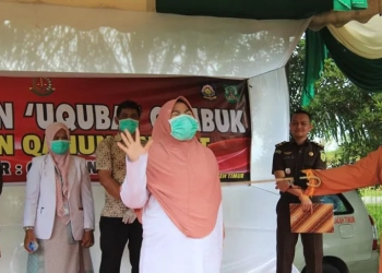 Terpidana pelanggaran syariat Islam mengangkat tangan ketika menjalani hukuman cambuk di halaman Kantor Dinas Syariat Islam Aceh Timur di Idi, Kamis (15/12). ANTARA/HO