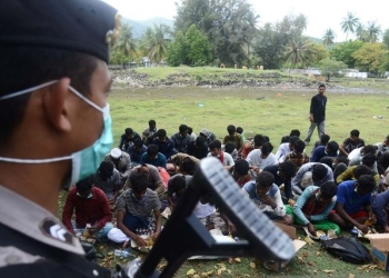 Personil Polda Aceh memberikan pengamanan kepada imigran etnis Rohingya setelah terdampar di pantai Desa Ladong, Kabupaten Aceh Besar, Aceh, Minggu (25/12/2022). (Dok. ANTARA FOTO/Ampelsa)