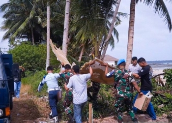 Tampak petugas Lanud Raden Sadjad saat mengamankan puing diduga mirip badan pesawat yang ditemukan warga di Pantai Air Danau, Sejuba, Desa Sepempang, Bunguran Timur, Natuna, Kepri, Sabtu (24/12). (ANTARA/Cherman)