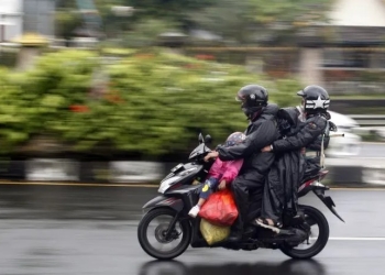 Pengendara sepeda motor mengenakan jas hujan saat melintas di jalur wisata Puncak, Gadog, Kabupaten Bogor, Jawa Barat, Sabtu (31/12/2022). ANTARA FOTO/Yulius Satria Wijaya/aww. (ANTARA FOTO/YULIUS SATRIA WIJAYA)