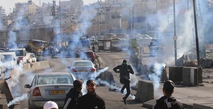 Arsip - Para warga Palestina pengunjuk rasa berlarian untuk berlindung dari tabung gas air mata yang ditembakkan oleh pasukan keamanan Israel dalam bentrokan di pos pemeriksaan Qalandia dekat Kota Ramallah di Tepi Barat (27/12/2022). (Antara Foto/Xinhua/Nidal Eshtayeh/aww)