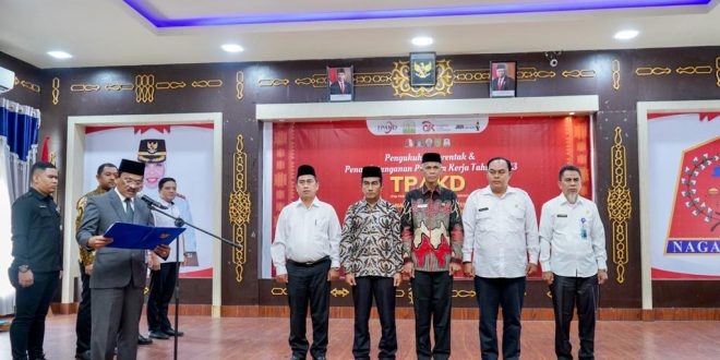 Penjabat (Pj) Gubernur Aceh yang diwakili Asisten II Sekda Aceh, Mawardi, mengukuhkan Tim Percepatan Akses Keuangan Daerah atau TPAKD pada lima Kabupaten/Kota dan Penandatanganan Program Kerja Tahun 2023, di Anjungan Meuligoe Bupati Nagan Raya, Rabu (1/2/2023). (Humas Pemerintah Aceh)