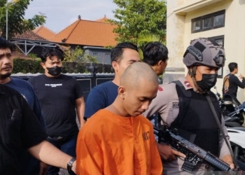 Polisi menggiring tersangka IKJ (18) yang diduga membunuh korban NMDS (16) yang masih berstatus sebagai pelajar SMK di Denpasar, Bali, Rabu (8/2/2023). ANTARA/Rolandus Nampu