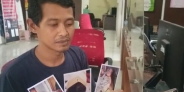Suparman (38), menunjukkan foto putranya berusia delapan bulan yang jari tangan bagian kelingkingnya diduga digunting oknum perawat rumah sakit Muhammadiyah Palembang saat membuat laporan di SPKT Kepolisian Resor Kota Besar Palembang, Sumatera Selatan, Sabtu (4/2/2023). (ANTARA/M Riezko Bima Elko P)