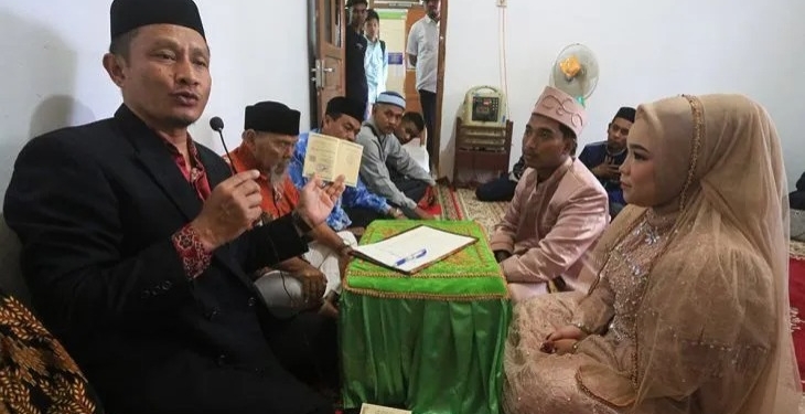 Kepala Kantor Urusan Agama (KUA) Ulee Kareng Harun Usman (kiri) saat membimbing sepasang pengantin yang melaksanakan akad nikah di KUA Ulee Kareng, Banda Aceh, Aceh, Kamis (23/2/2023). ANTARA/Khalis Surry