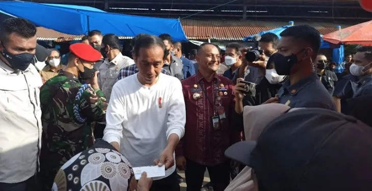 Presiden RI Joko Widodo memberikan bantuan kepada warga saat mengunjungi Pasar Batuphat, Kecamatan Muara Satu, Kota Lhokseumawe, Jumat (10/2/2023). (ANTARA/HO/Dok Humas Pemkot Lhokseumawe)