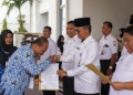 Asisten Administrasi Umum Sekda Aceh, Iskandar, menyerahkan 678 SK kenaikan pangkat TMT 1 April 2024 dan SK Pensiun untuk pegawai Pemerintah Aceh, di Kantor Walikota Lhokseumawe, Rabu (15/3/2023). (Foto: ALIBI/Dok. Humas Pemerintah Aceh)