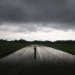 Arsip Foto. Mendung penanda hujan meliputi bagian langit di atas daerah Sawit, Boyolali, Jawa Tengah, Rabu (1/3/2023), saat seorang petani bekerja di lahan padinya. (ANTARA FOTO/Aloysius Jarot Nugroho)
