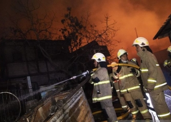 Sejumlah petugas berusaha memadamkan api yang membakar rumah warga imbas kebakaran Depo Pertamina Plumpang, kawasan Jalan Koramil, Rawa Badak Selatan, Koja, Jakarta Utara, Jumat (3/3/2023). ANTARA FOTO/M Risyal Hidayat/tom.