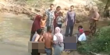 Warga melakukan evakuasi terhadap tiga anak yang tenggelam di sungai Gampong Blang Minjei, Kecamatan Idi Tunong, Aceh Timur, Aceh, Minggu (16/4/2023). (Foto: Alibi/Dok. Polisi)