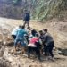 Warga bersama petugas kepolisian membantu mengevakuasi pengendara sepeda motor yang terjebak tanah longsor di badan jalan provinsi di kawasan Simpang Baibon, Kecamatan Sungai Mas, Kabupaten Aceh Barat, Senin (8/5/2023). (Foto: Antara/HO)