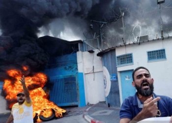 Sejumlah warga Palestina membakar ban bekas di depan kantor United Nations Works and Relief Agency (UNRWA) saat berunjuk rasa di Gaza City, Senin (19/9/2022). (Foto: Antara/REUTERS/Mohammed Salem/wsj)