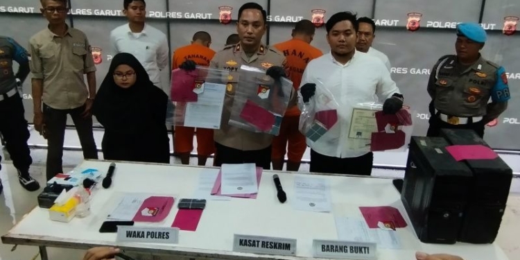 Polisi menunjukkan barang bukti dan tersangka kasus perdagangan orang modus penyaluran tenaga kerja migran di Kabupaten Garut, Jawa Barat, Senin (19/6/2023). (Foto: Antara/Feri Purnama)