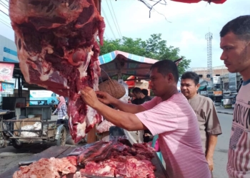 Pedagang daging di Pasar Darussalam, Banda Aceh sedang melayani pembeli. (Foto: Alibi/Fahzian Aldevan)