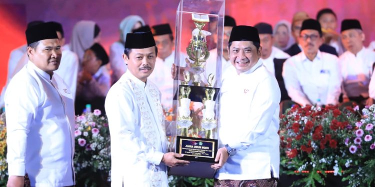 Kepala Kanwil Jateng Mustain Ahmad menerima piala juara umum dari Dirjen Pendis Ali Rhamdani. (Foto: Alibi/Dok. Kemenag RI)