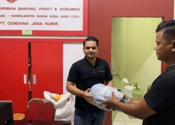 Petugas ekspedisi menyerahkan paket berisi ganja ke personel Ditresnarkoba Polda Aceh di Banda Aceh. (Foto: Alibi/Dok. Polda Aceh)