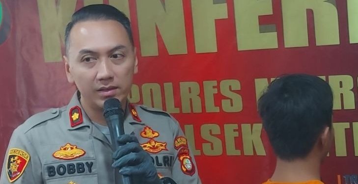 Kepala Polsek Metro Penjaringan Komisaris Polisi M Probandono Bobby Danuardi (kiri) menunjukkan tersangka agen penyalur korban TPPO. (Foto: Antara/Abdu Faisal)