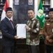 Penjabat Gubernur Aceh, Achmad, menyerahkan SK Perpanjangan Masa Jabatan Pj Bupati Bireuen, Aulia Sofyan, di Banda Aceh, Selasa (15/8/2023). (Foto: Alibi/Dok. Humas Aceh)