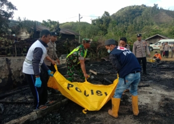Tim medis dibantu pihak keamanan mengevakuasi jasad May Syaratdin (43), korban kebakaran di Desa Timur Jaya, Kecamatan Permata, Bener Meriah, Aceh. (Foto: Alibi/Dok. Polisi)