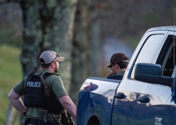 Anggota kepolisian berjaga di jalan menuju kediaman ayah dari Robert Card yang terletak di Bowdoin, yang berjarak sekitar 24 kilometer dari Lewiston, Maine, Kamis (26/10/2023). (Foto: Dok. AFP/Joseph Prezioso)