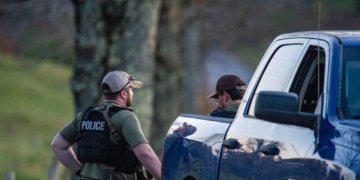 Anggota kepolisian berjaga di jalan menuju kediaman ayah dari Robert Card yang terletak di Bowdoin, yang berjarak sekitar 24 kilometer dari Lewiston, Maine, Kamis (26/10/2023). (Foto: Dok. AFP/Joseph Prezioso)