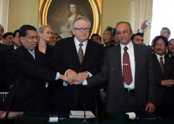 Martti Ahtisaari (tengah), Hawil Awaluddin (kiri) dan Malik Mahmud (kanan) berjabat tangan usai menandatangani MOU Helsinki. (Foto: Dok. Wikipedia)
