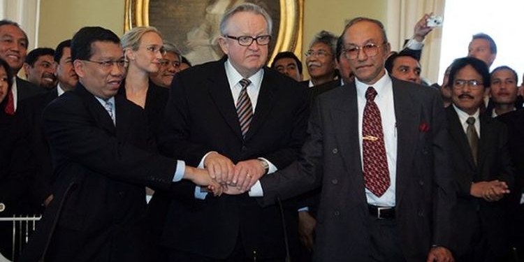 Martti Ahtisaari (tengah), Hawil Awaluddin (kiri) dan Malik Mahmud (kanan) berjabat tangan usai menandatangani MOU Helsinki. (Foto: Dok. Wikipedia)