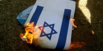 Bendera Israel dibakar. (Foto: AFP/Mahmoud Zayyat)