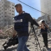 Jurnalis Palestina meliput Menara Jala yang hancur setelah serangan udara Israel di Jalur Gaza, Palestina, pada (15/5/2021). (Foto: MOHAMMED ABED/AFP)