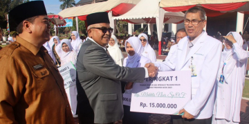 Sekda Aceh, Bustami didampingi Kadinkes Aceh Munawar menyerahkan penghargaan kepada tenaga kesehatan saat menjadi Inspektur Upacara Peringatan Hari Kesehatan Nasional (HKN) ke-59 di Halaman Kantor Gubernur Aceh, Banda Aceh, Senin (13/11/2023). (Foto: Biro Adpim Pemprov Aceh)