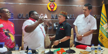 Ketua Umum KONI Papua memakaikan Noken, tas tradisional khas Papua kepada Ketua Umum KONI Aceh. (Foto: Dok. Koni Aceh)