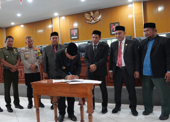Pj Bupati Aceh Jaya, Nurdin menandatangani pengesahan APBK Aceh Jaya tahun 2024 pada rapat paripurna di ruang rapat Kantor DPRK Setempat, Selasa (28/11/2023). (Foto: Dok. Humas Aceh Jaya)