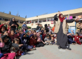 Seorang sukarelawan berinteraksi dengan anak-anak selama kegiatan stimulasi dan bantuan psikologis di sebuah sekolah yang berafiliasi dengan Badan Bantuan dan Pekerjaan PBB untuk Pengungsi Palestina (UNRWA) di kota Khan Younis, Jalur Gaza selatan, 23 November 2023. (Rizek Abdeljawad/Xinhua)