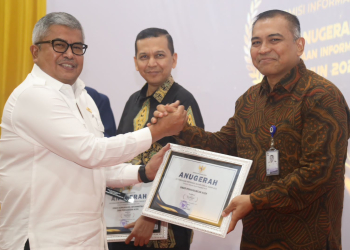 Sekda Aceh, Bustami menyerahkan penghargaan kepada pemenang Anugerah Keterbukaan Informasi Publik Tahun 2023 yang diselenggarakan Komisi Informasi Aceh di Aula Amel Convention Hall, Banda Aceh, Rabu, (6/12/2023). (Foto: Dok. Adpim Pemprov Aceh)