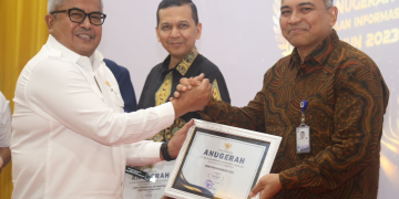 Sekda Aceh, Bustami menyerahkan penghargaan kepada pemenang Anugerah Keterbukaan Informasi Publik Tahun 2023 yang diselenggarakan Komisi Informasi Aceh di Aula Amel Convention Hall, Banda Aceh, Rabu, (6/12/2023). (Foto: Dok. Adpim Pemprov Aceh)
