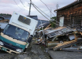 Puing-puing berserakan dan kendaran amblas masuk jalan yang rusak akibat gempa terlihat di Kota Wajima, Prefektut Ishikawa, Jepang, 5 Januari 2024. (Foto: Kyodo)