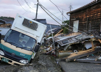 Puing-puing berserakan dan kendaran amblas masuk jalan yang rusak akibat gempa terlihat di Kota Wajima, Prefektut Ishikawa, Jepang, 5 Januari 2024. (Foto: Kyodo)